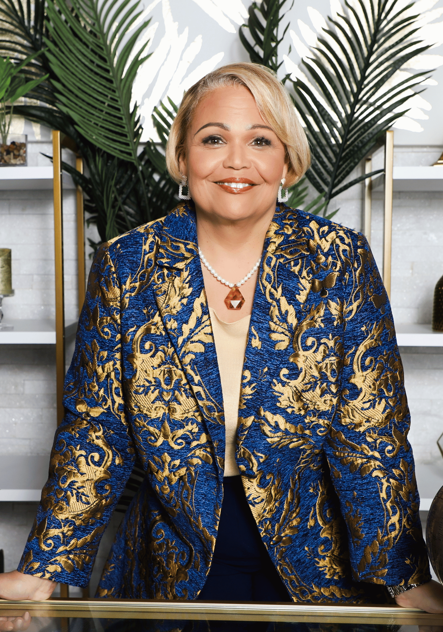 Dr. Vicki Wright Hamilton standing confidently in a modern office setting with gold and green decor, showcasing her leadership and business expertise.